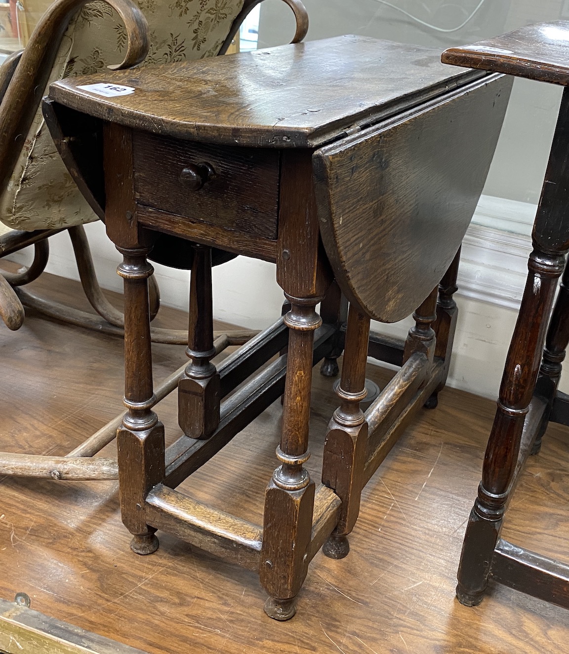 A Charles II and later oak small oval gateleg table, with a drawer, square and column turned legs joined by stretchers, width 72cm, depth 29cm, height 60cm